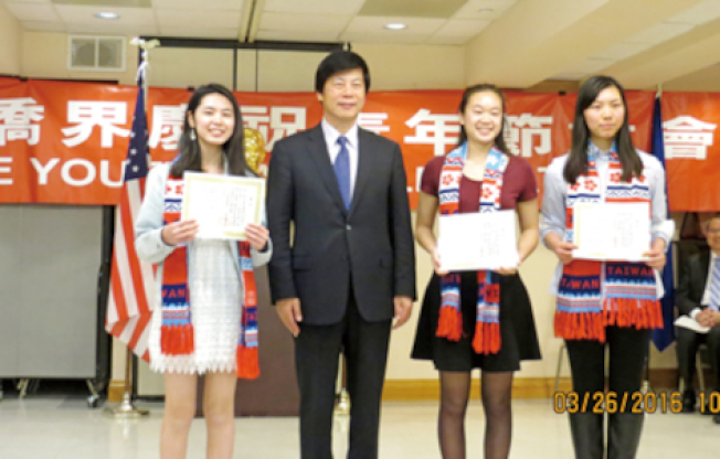 馬鍾麟（左二）頒贈中華民國國旗圍巾給三名學生。左一為宣讀大會宣言的黃韻意，右起大會司儀劉霖和主席歐紀瑩。（主辦單位提供）

